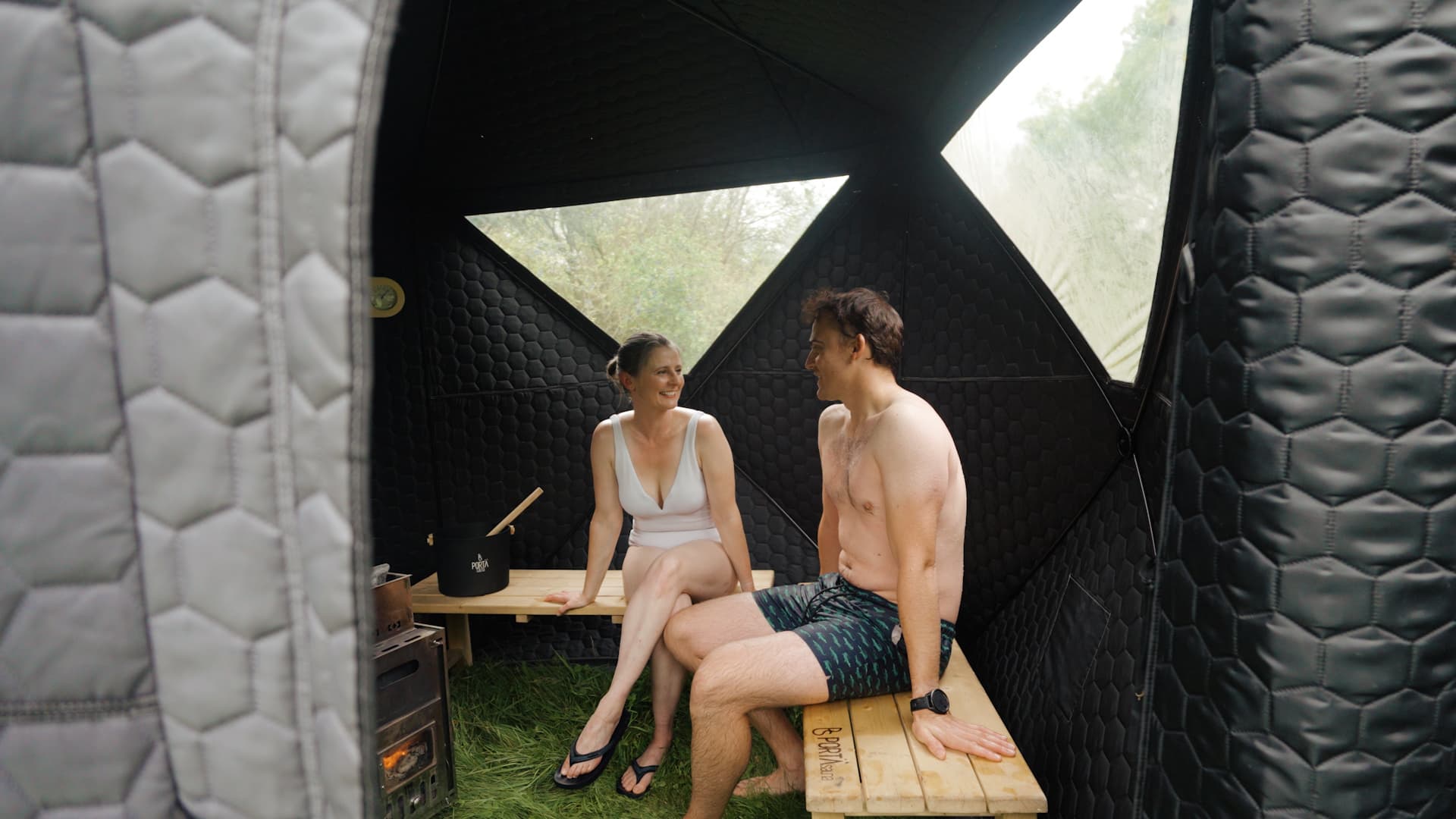 Couple relaxing inside the sauna tent